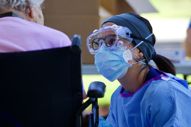 A nurse speaks to an older patient