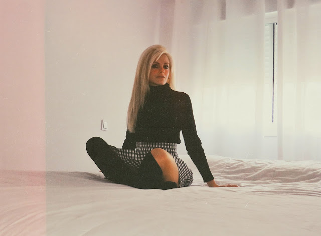 Alejandra Colomera con jersey negro, falda de cuadros vichy negros y calcetas negras