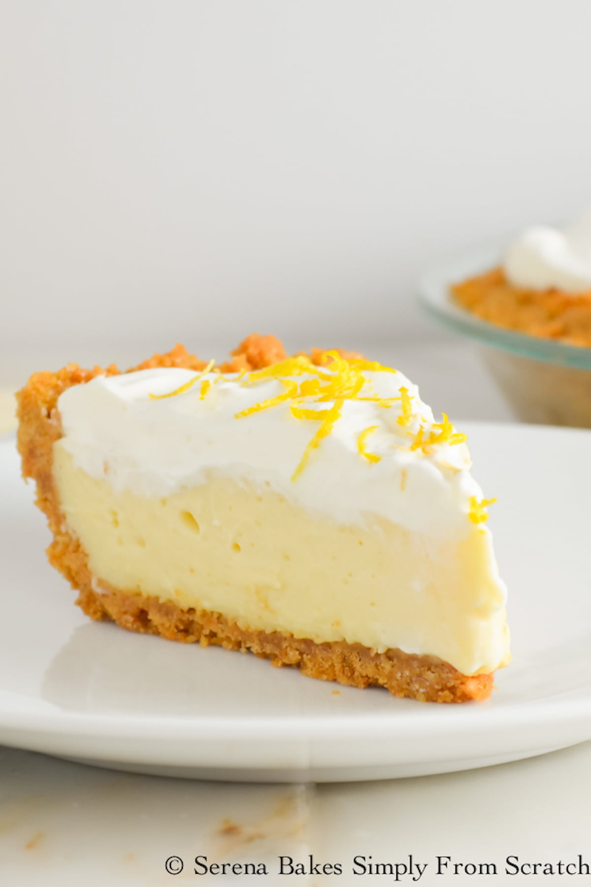 A slice of Lemon Pudding Cheesecake on a white plate.