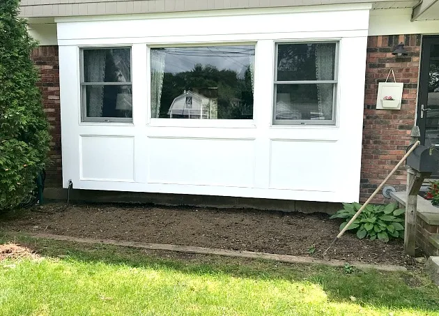 Front window of the house with garden bed