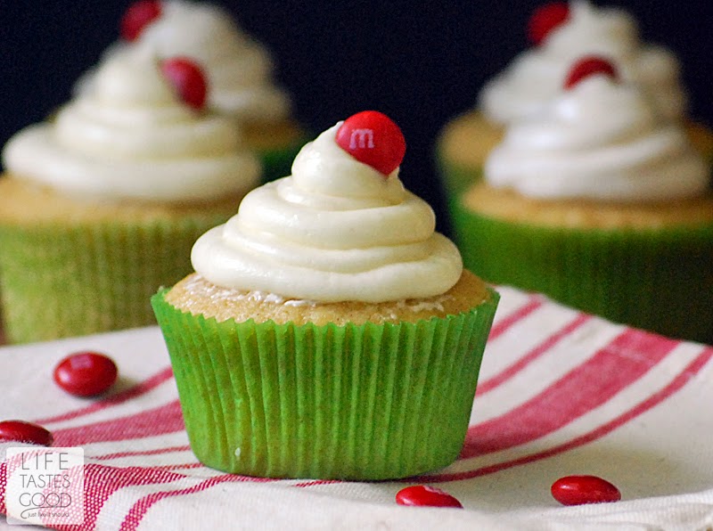 Applesauce Cupcakes in a green cupcake liner topped with white meringue frosting and a red M&M