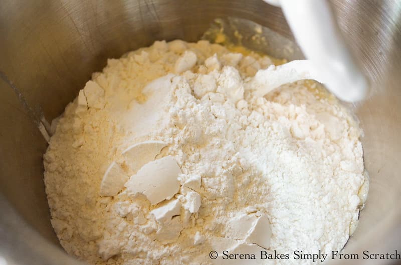 Flour and Salt added to foamy yeast mixture in a stainless steel bowl.
