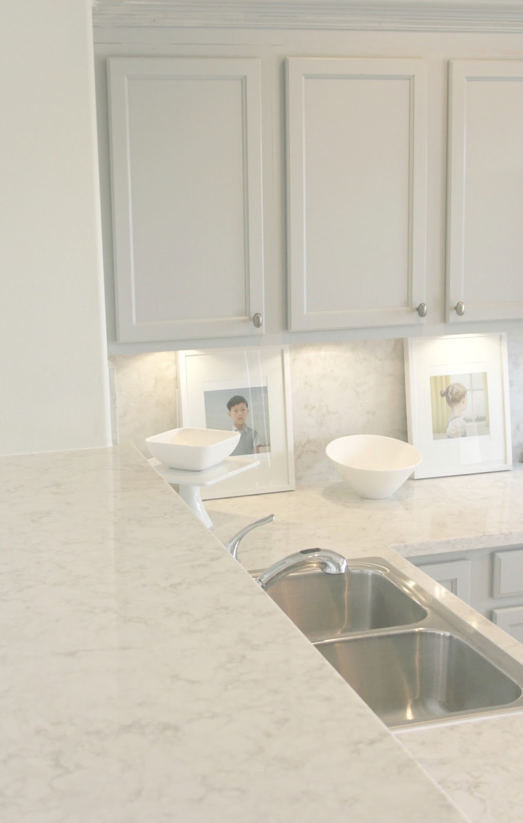 Serene chic simple Nordic French kitchen with grey cabinets and Soprano quartz countertop and backsplash