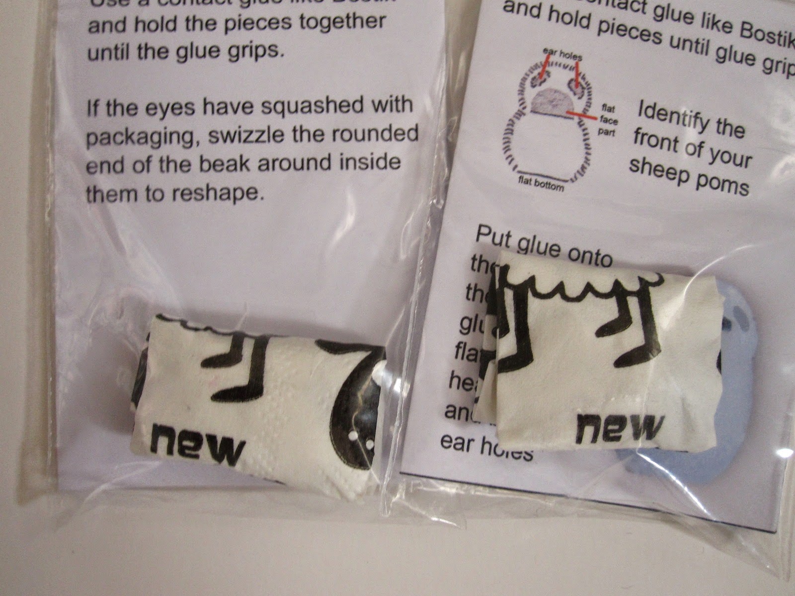The back of two bagged miniature cuddly toy kits, showing the pieces wrapped in New Zealand themed tissues.