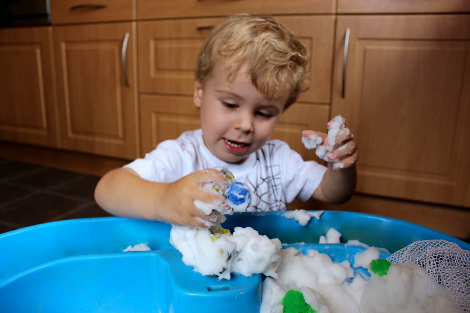 Snowy sensory play activity for toddlers and preschoolers.  Create a simple small world winter snow scene using foam soap, penguins and polar bears.