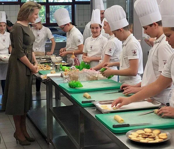 Queen Mathilde wore a khaki midi dress by Natan. Tiffany Italy gold leaf brooch, Canadian maple leaf brooch and gold earrings