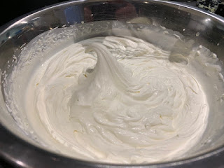 A silver bowl filled with whipped cream