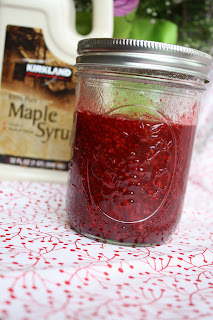 a clear glass pint mason jar with pureed raspberry syrup 