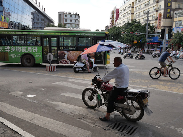 man riding a motorcycle the wrong direction on a road