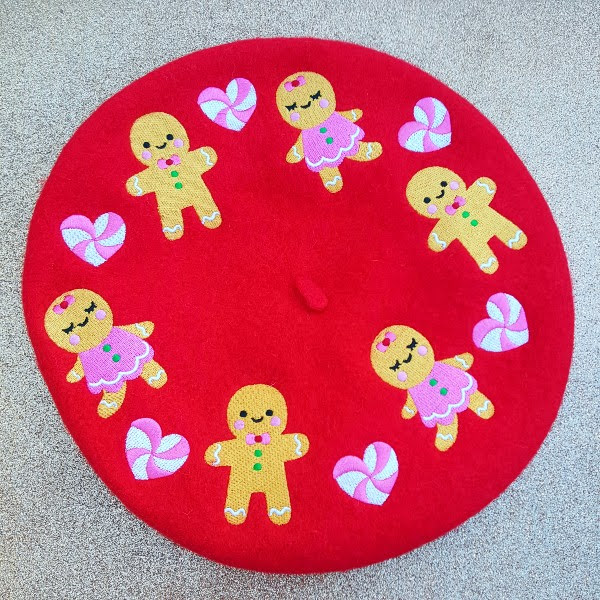red wool beret with gingerbread men and girls and hearts embroidered