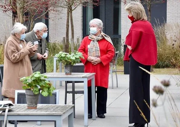 Queen Mathilde wore a rosetta insignia crepe pussy bow blouse from Carolina Herrera, and a red wool cape jacket from Armani and Massimo Dutti Natan