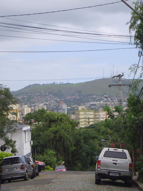 Rua Felizardo Furtado, no Bairro Petrópolis, em Porto Alegre, Rio Grande do Sul. Imagem apresenta tarde com céu parcialmente nublado, após rápido chuvisqueiro. Ao fundo, o Morro da Embratel