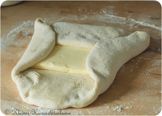 Die Kanten des Teiges wie einen Briefumschlag um die Butterplatte schlagen