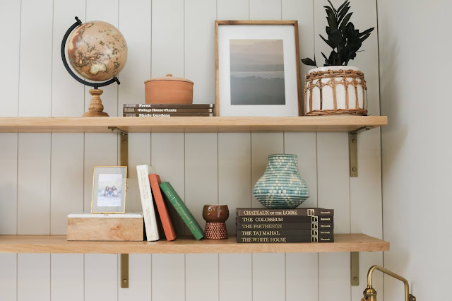 Shelfie with books, decorative objects, photos, and plants