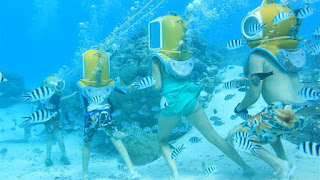 Groupe de personnes en scaphandre sous l'eau. Visite des récifs coralliens à Tahiti.