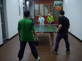 four men playing ping-pong