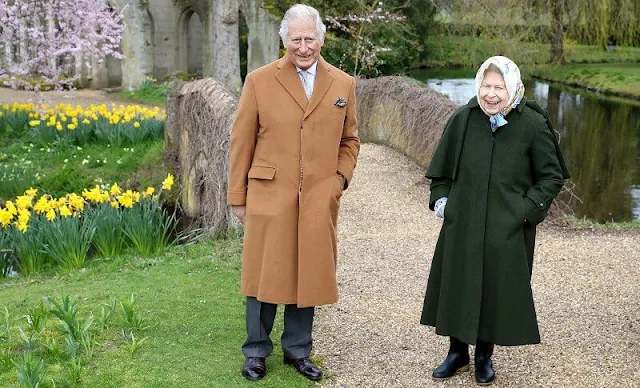 Queen Elizabeth wore a green jacket with caped detailing on the sleeves, and a patterned silk scarf. Prince Charles wore a camel coat and dark trousers