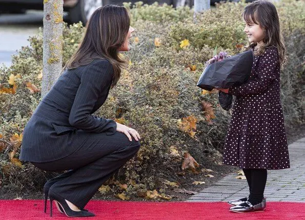 Healthcare Denmark. dark grey pinstripe belted blazer, pinstripe blazer pants suit. Crown Princess Mary wore a drop earrings from Marianne Dulong