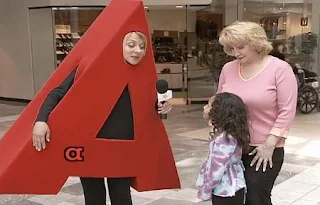 Nicole Sullivan as the letter A interviews a little girl. Sesame Street All Star Alphabet