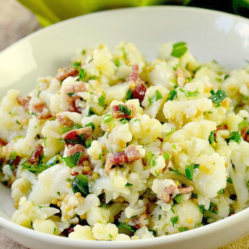 This low carb and keto-friendly cauliflower salad recipe is easy to make and sure to become a favorite side for all of your barbecues, picnics, and summer parties! Light and bright, it is chock full of herbs, and with zero mayo, it is perfect for the dairy-free crowd too! #keto #lowcarb #dairyfree #cauliflower #salad #sidedish #easy #recipe | bobbiskozykitchen.com