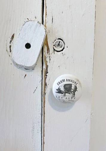 Cupboard door latch with transfer on knob.
