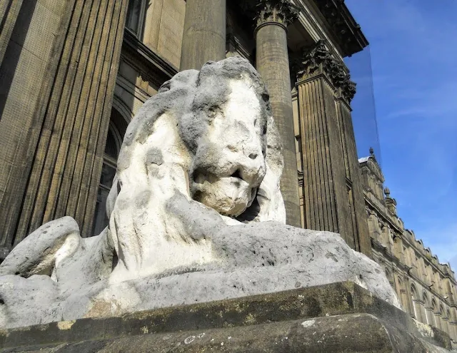 Weather-worn stone lion in Leeds England