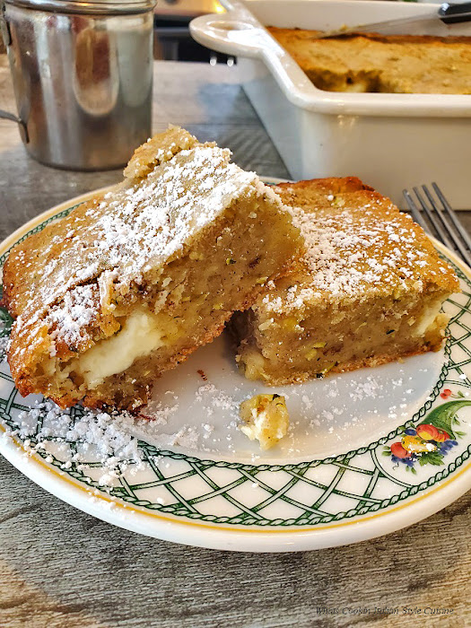 A delicious cake that is filled with cream cheese inside the batter is made with zucchini and ripe bananas