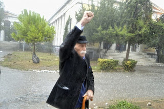 Ce 17 novembre 2019, Manolis Glézos, cheveux longs blanchis par le temps, est photographié, main droite sur sa canne, poing gauche levé. Il assiste à la commémoration du «soulèvement de l’Ecole Polytechnique». Le 17 novembre 1973, des jeunes Grecs se soulevaient contre une junte arrivée au pouvoir en 1967 avec l’aide des Américains, et qui n’allait le quitter qu’en juillet 1974.