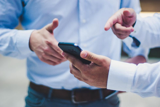 Two men looking at a smartphone