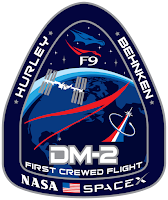 Po lewej: Dragon 2 na szczycie rakiety Falcon 9 z widocznym zmodyfikowanym przez SpaceX ramieniem dostępowym załogi na stanowisku startowym LC-39A w Centrum Kosmicznym Kennedy'ego. Po prawej: logo misji DM-2. Credit: SpaceX