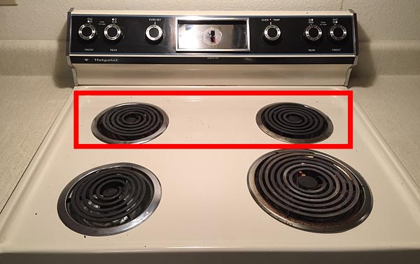 photo of a four-burner electric stove; the two burners in the back have been outlined with a red box