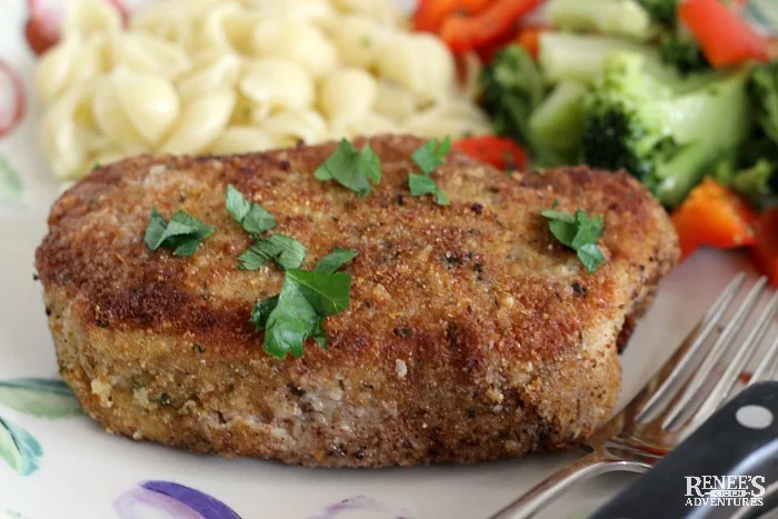 Close up Breaded Oven Baked Pork Chop on a plate with a fork