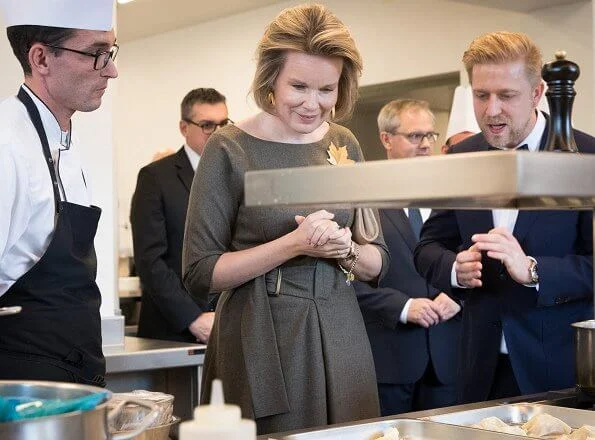 Queen Mathilde wore a khaki midi dress by Natan. Tiffany Italy gold leaf brooch, Canadian maple leaf brooch and gold earrings