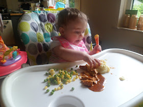 Example of baby led weaning - baby eating Vinaigrette Chicken, cheesy mash, peas and sweetcorn
