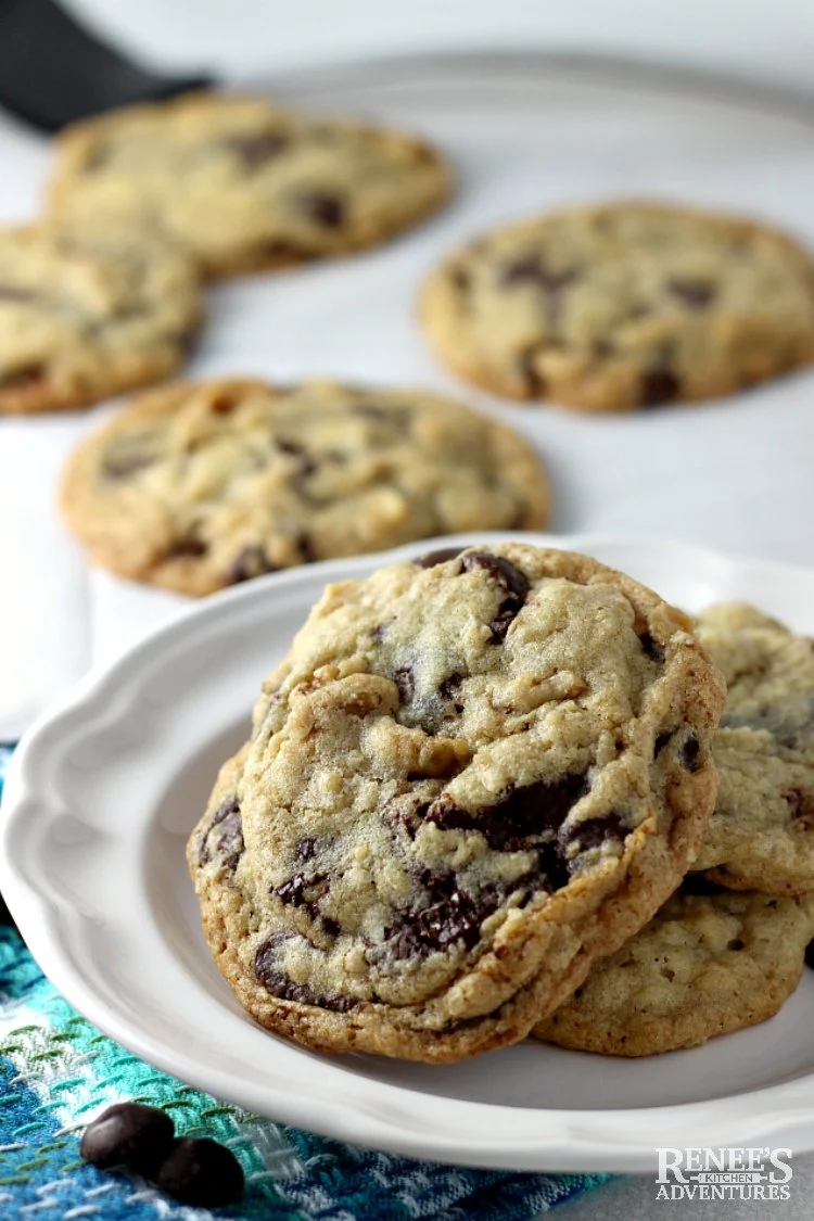 DoubleTree Chocolate Chip Cookies on white plate with chips scattered around plate and more cookies in background