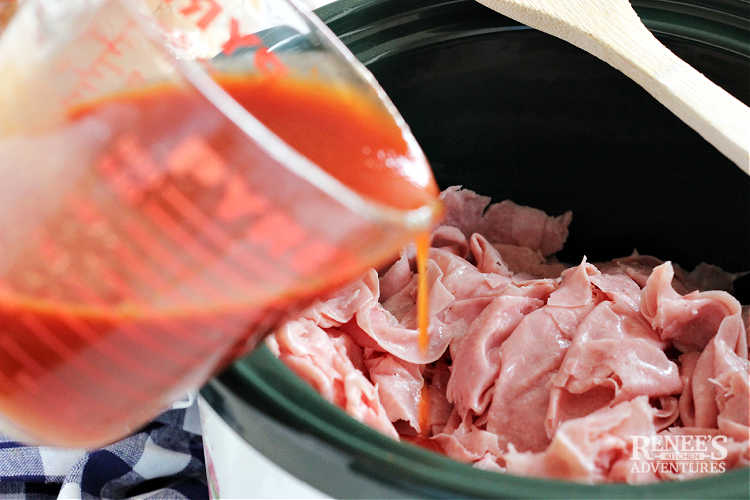 Pouring homemade BBQ sauce onto chipped chopped ham in slow cooker