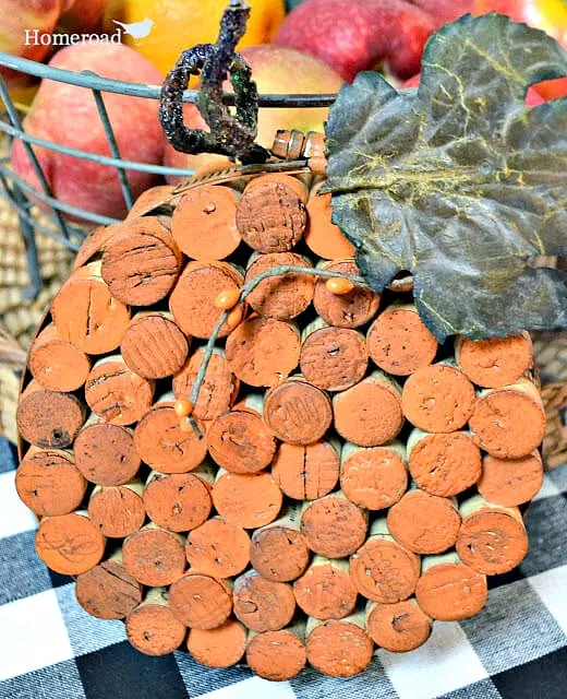 Orange painted cork circle with leaf and stem