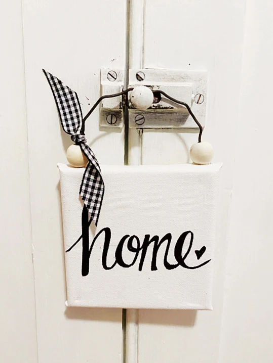 home sign hanging on a door