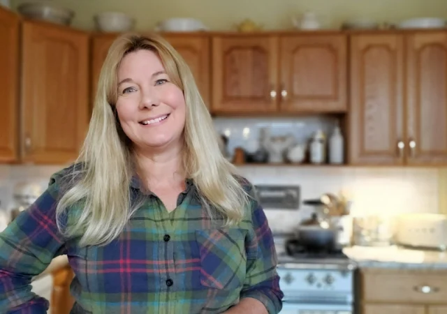 woman in plaid flannel shirt standing in kitchen