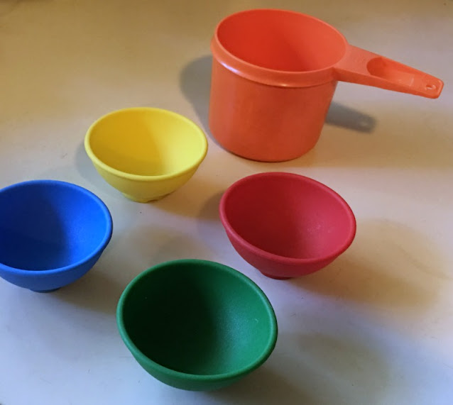Norpro set of 4 silicone mini pinch bowls next to 1-cup measuring cup