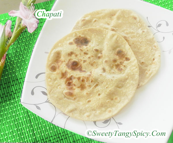 A plate of freshly cooked chapatis, soft and golden-brown, served with a spicy gravy, showcasing a delightful Indian meal.