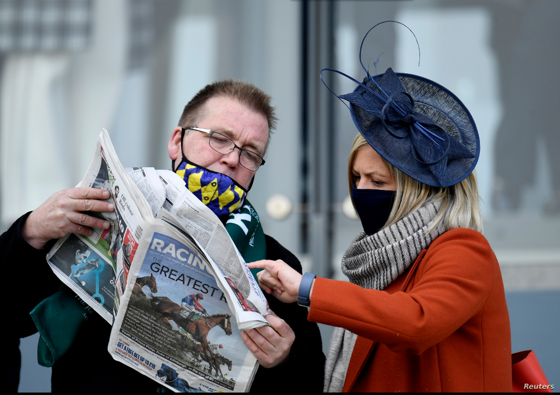 Dos personas miran un periódico en la ciudad de Liverpool, Reino Unido, el 10 de abril de 2021 / REUTERS 