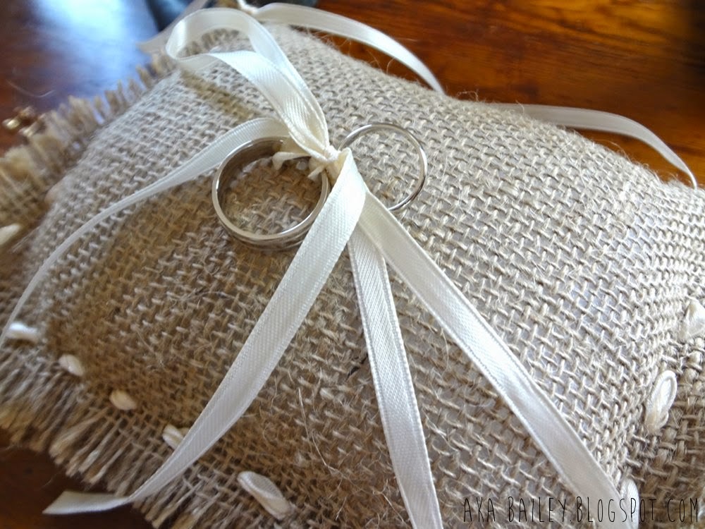 Wedding rings tied with a ribbon onto a burlap pillow
