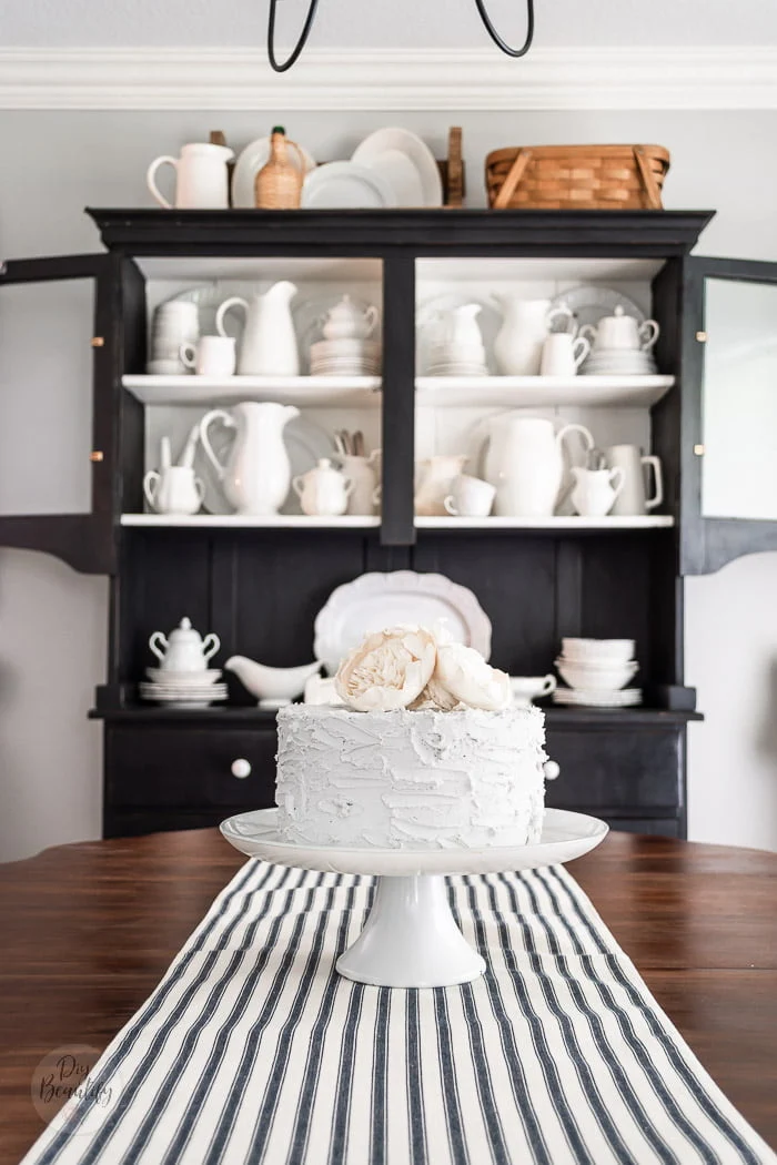 fake cake with wood flowers, black hutch and ironstone