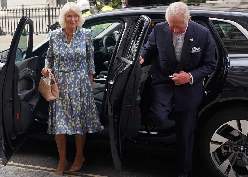 Camilla wore a floral silk blue dress from Fiona Clare, and she carried beige leather bag from Bottega Veneta