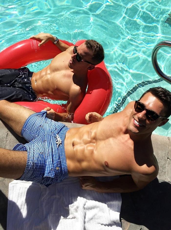 two-fit-shirtless-sixpack-abs-bros-sun-tanning-pool-water-shorts-sunglasses-towel-laying-beautiful-smile-gay-bottoms
