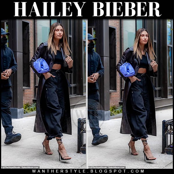 Hailey Bieber in long black coat with purple clutch bag on May 18