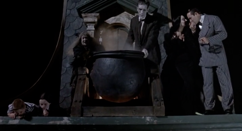 The-Addams-Family-waiting-on-roof-to-dump-boiling-oil-on-carolers.png