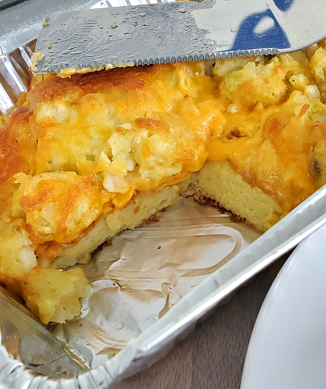 this is a breakfast all in one casserole in a foil pan with tater tots cheese eggs and sausages