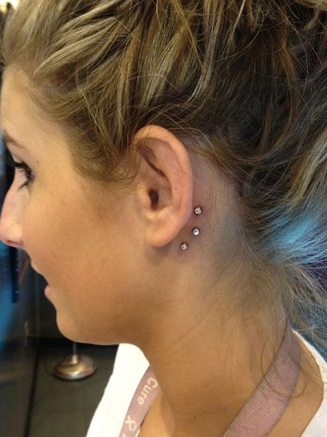 donna con dermal piercing dietro l'orecchio